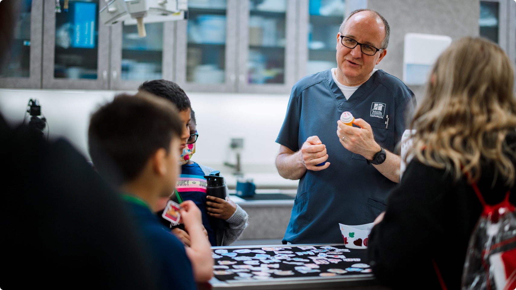 Hill's Pet Nutrition Center researcher showing the pet food lab to a group of kids